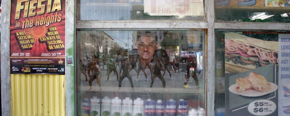 Usnavi peers out at the action on the streets surrounding the local bodega.