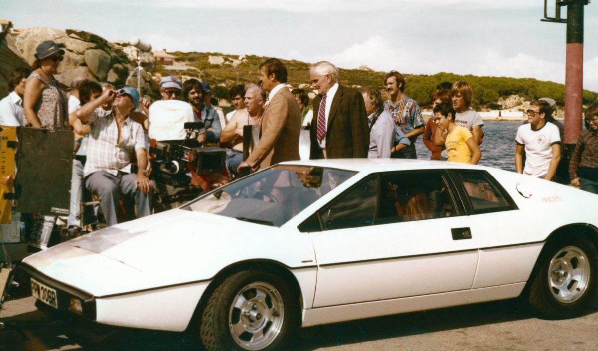 At the camera, French director of photography Claude Renoir checks his light while shooting the scene in which gadgets master “Q” (Desmond Llewelyn) hands Bond the keys to the specially equipped Lotus Esprit.