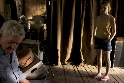 Abner (Hal Holbrook) is visited by Pamela (Mia Wasikowska) inside the dark tenant shack
