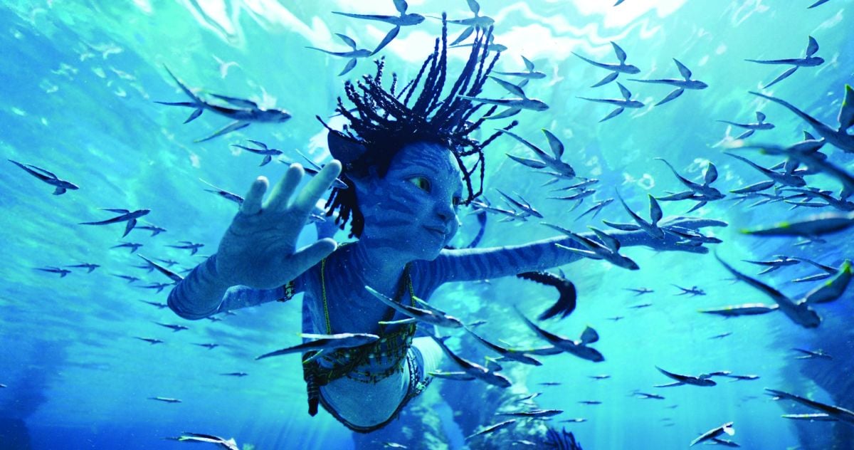 Jake and Neytiri’s daughter, Tuk (Trinity Jo-Li Bliss), swims with a school of fish.