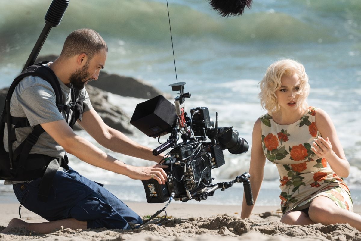 Irvin meets de Armas at eye level while filming a beach scene.