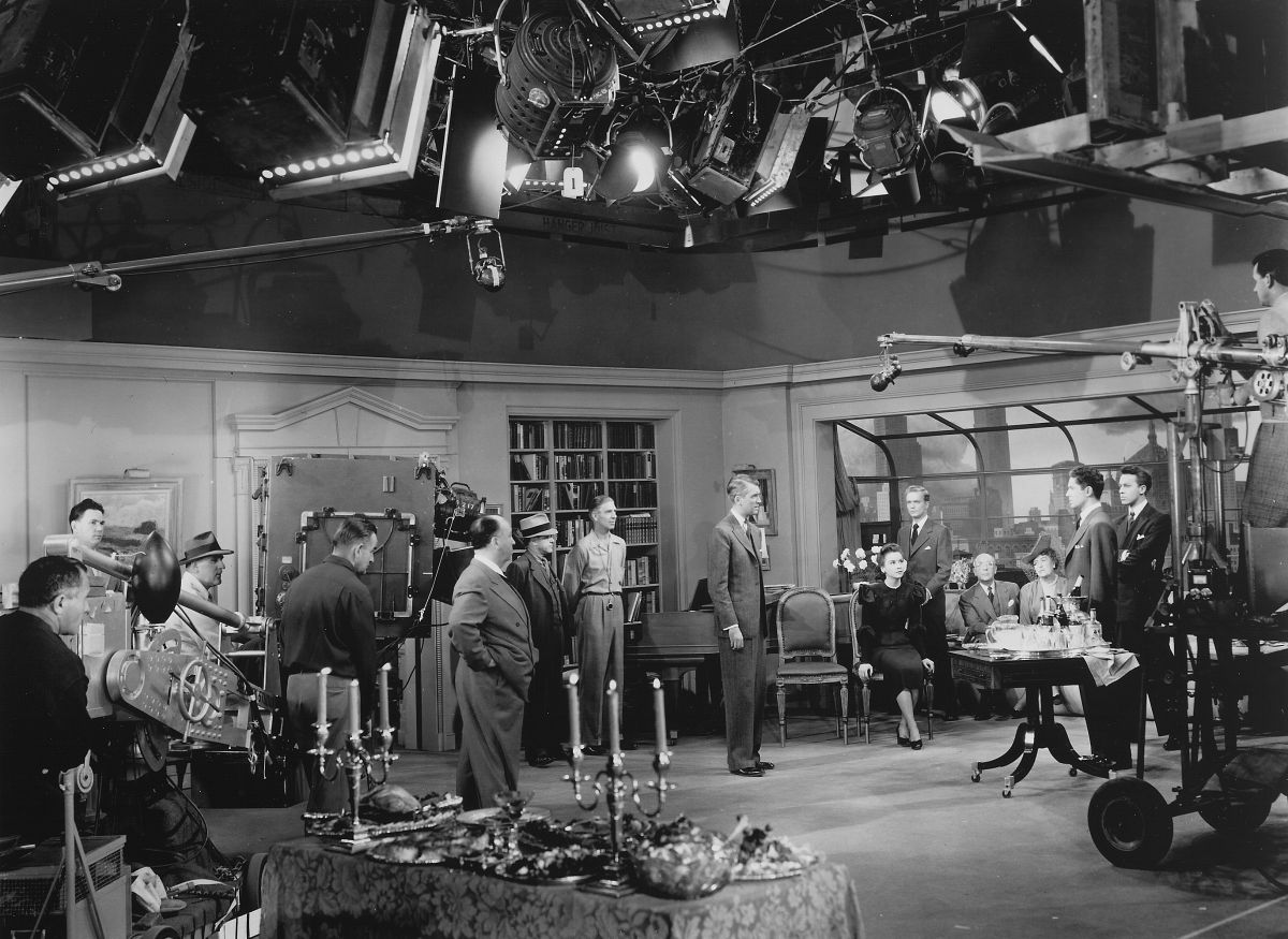 Hitchcock and his camera crew — including ASC members Joseph A. Valentine and William V. Skall (standing in front of camera) — rehearse to shoot one of the 10 lengthy shots (up to 10 minutes each) seen in the thriller Rope (1948), which was written, choreographed, photographed and edited to appear to be one single, continuous shot taking place in real time. This was also the director's first Technicolor project.
