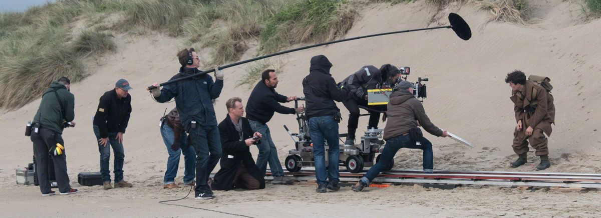 The Dunkirk production crew sets their next shot on the beach.