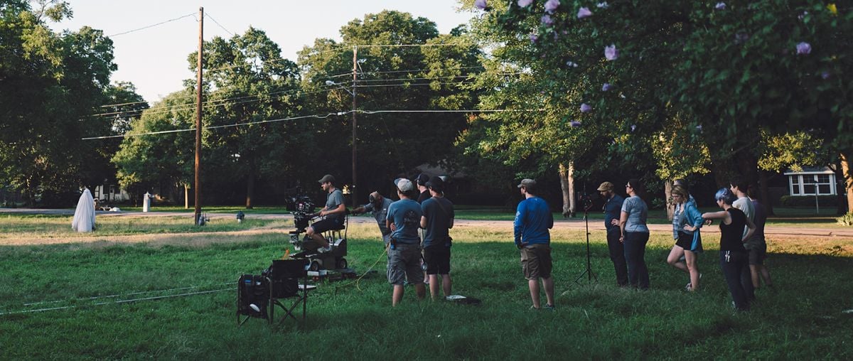 The crew captures a dolly shot as the ghost makes his way to the house.