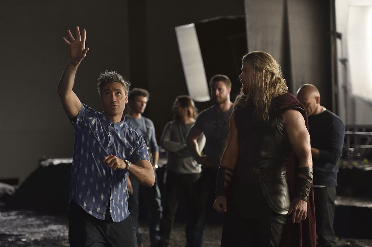 Director Taika Waititi (left) goes over a scene with Chris Hemsworth (portraying Thor).
