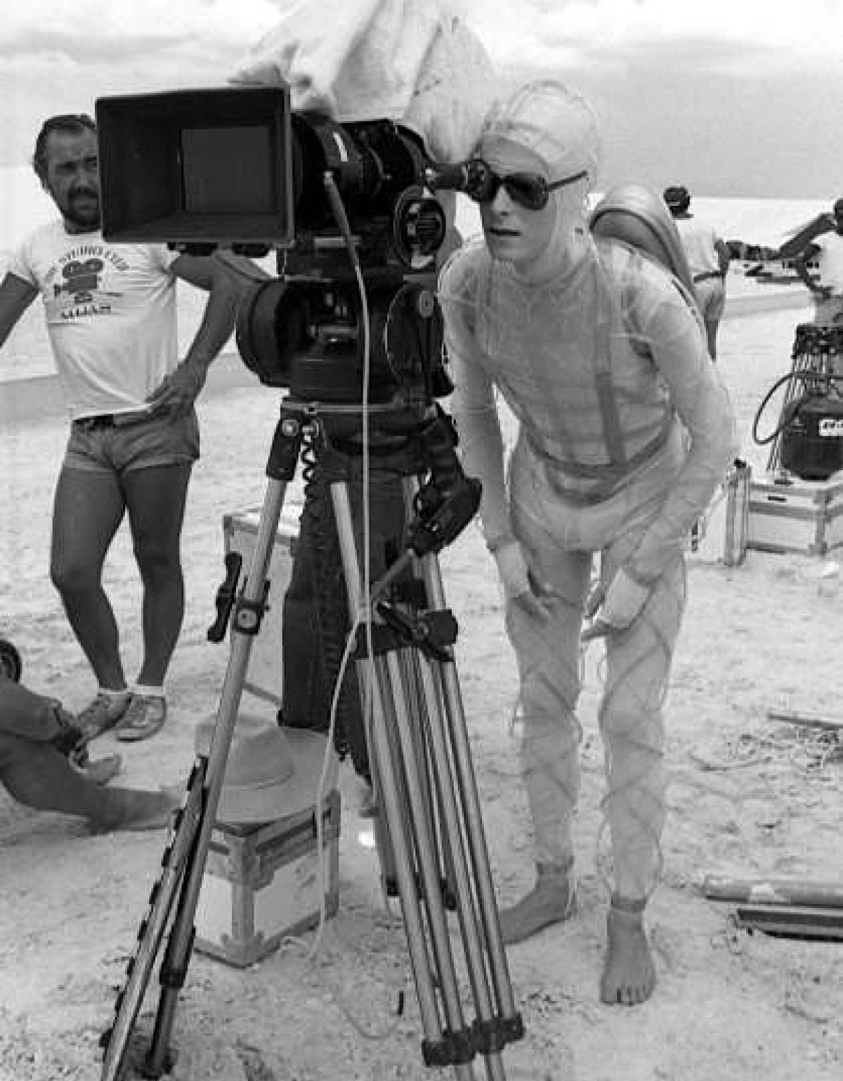 Bowie takes aim as Richmond (center) stands by while filming The Man Who Fell to Earth.