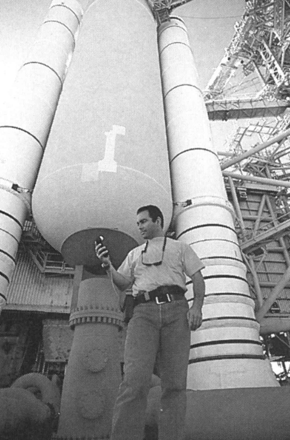Director of photography John Schwartzman at the base of a "locked and loaded" space shuttle at the Kennedy Space Center. The cameraman notes, "In one respect, NASA is of the highest technical order, but like everybody else, they're working within very strict budget restraints." Administration officials were very impressed by some of the cameraman's lighting gear: "They loved the fact that we brought all of this new technology to them. Our technology is much more current that NASA's. Anybody there would admit it. For example, the shuttle itself is a 1970s design. My PowerBook laptop is more powerful than any single computer in the firing room [where shuttle launches are coordinated]. It's just that all of their systems run perfectly, and look really cool."