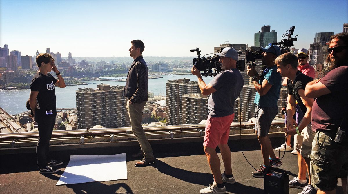 Prepping to shoot double coverage on the rooftop of the Manhattan Municipal Building, located at the foot of the Brooklyn Bridge, Collins (in pink shorts)  blocks out angles with stand-ins. In the scene, Dr. Reinhart has tracked a backpack bomber to the rooftop, where he confronts him in the climactic scene of the episode, directed by Gus Makris. To photograph the bomber jumping off the rooftop, Collins says, “stunts had laid out a large landing pad on the terrace two floors down and our actor started the leap, and then a stunt performer made the actual jump. We also combined some plates of the skyline and Brooklyn Bridge that our VFX company, The Molecule, composited together to alter the actual skyline on the rooftop.” 