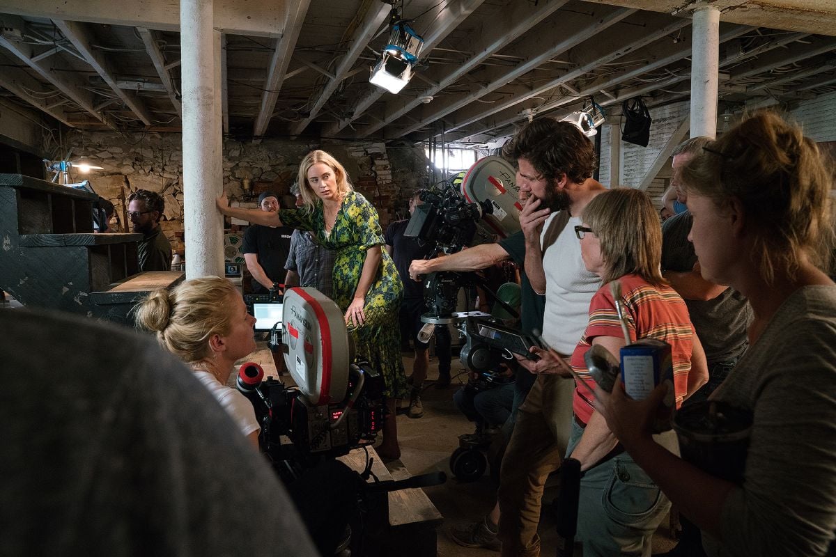At right, Christensen (behind camera) confers with Krasinski (center) as they block out a scene with actress Emily Blunt in the farmhouse cellar.