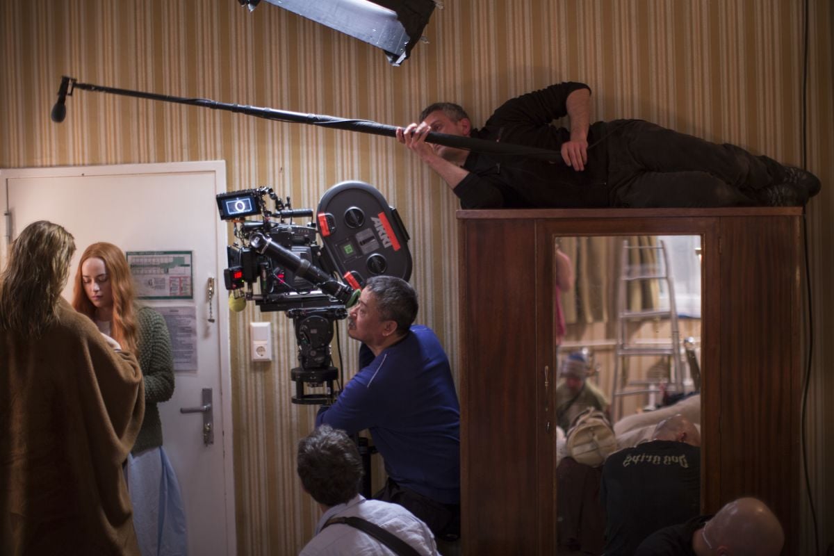 Mukdeeprom operates the camera as cast and crew work in tight quarters.