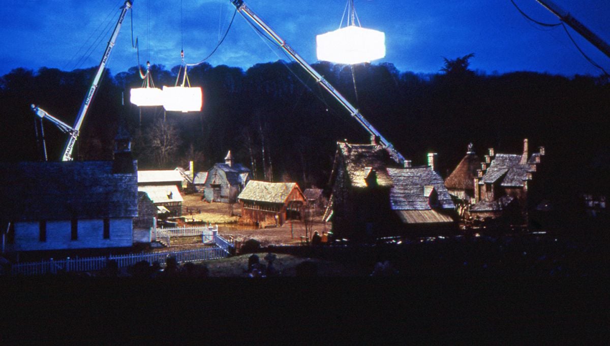 Suspendidos en grúas de construcción de servicio pesado, tres softboxes gigantes iluminan el centro de la ciudad de Sleepy Hollow, un conjunto exterior muy detallado construido en Marlow, Inglaterra.