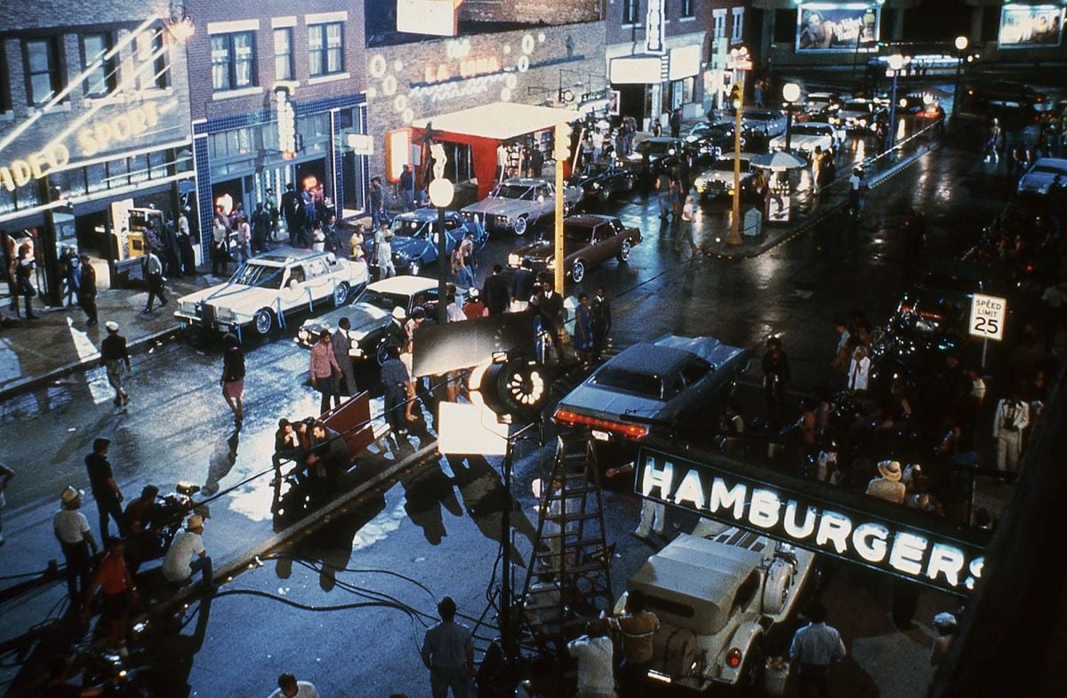 Shooting the neon-lit street scene in Tulsa, Oklahoma, the camera angles in on the cast sitting on a bench. (Photo courtesy of the Academy of Motion Picture Arts & Sciences)