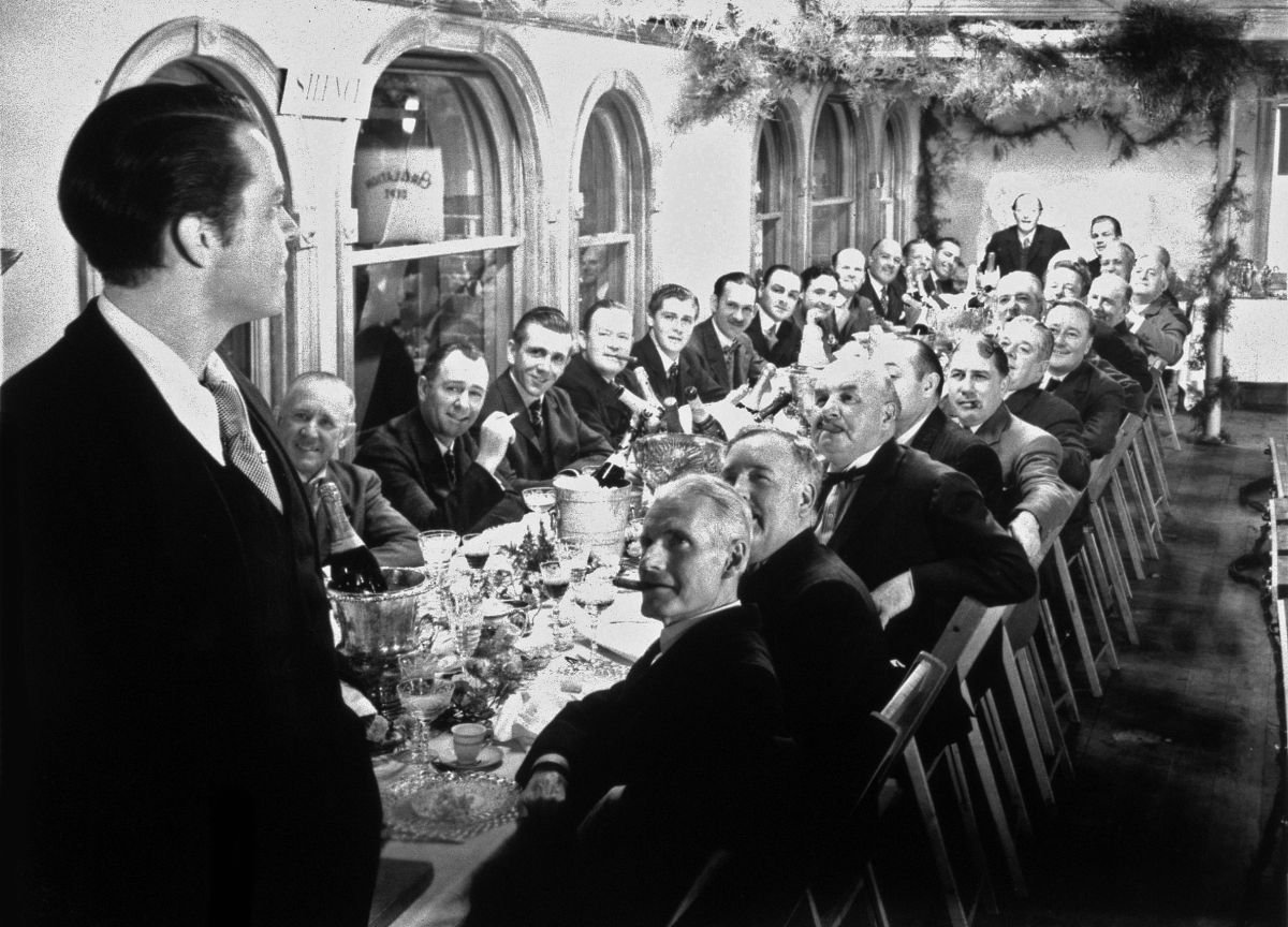 In Citizen Kane (1941), Charles Foster Kane (Orson Welles) addresses his New York Daily Inquirer staff. This image typifies cinematographer Gregg Toland, ASC’s extensive use of “deep focus” in the picture, rendering every element in the shot with total sharpness and allowing the audience to study the entire image. This was accomplished by Toland throughout the film with a combination of extremely high lighting levels and various pre-planned optical and visual-effects techniques.