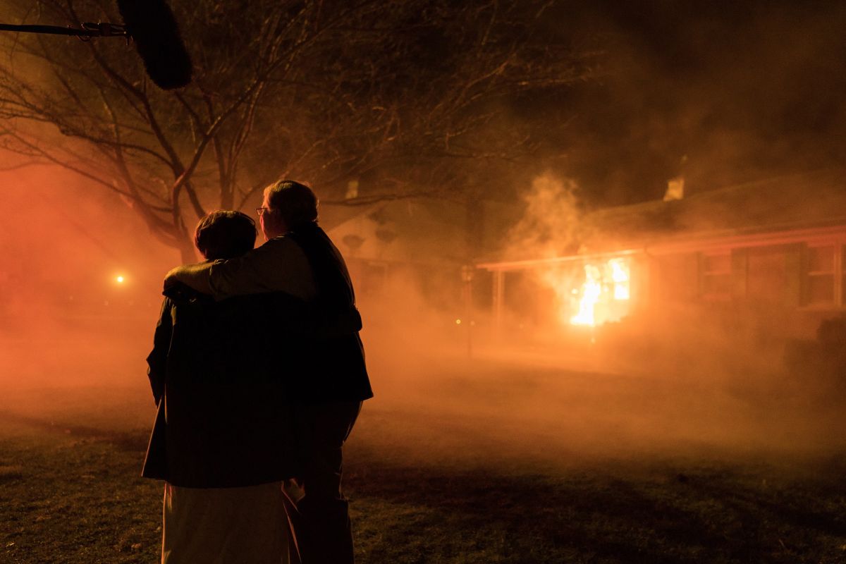 The Kigers, major plaintiffs in the case, watch a house burn under suspicious circumstances. To achieve the effect, the front of a real house was rigged with a fireproof false front and actually set aflame.