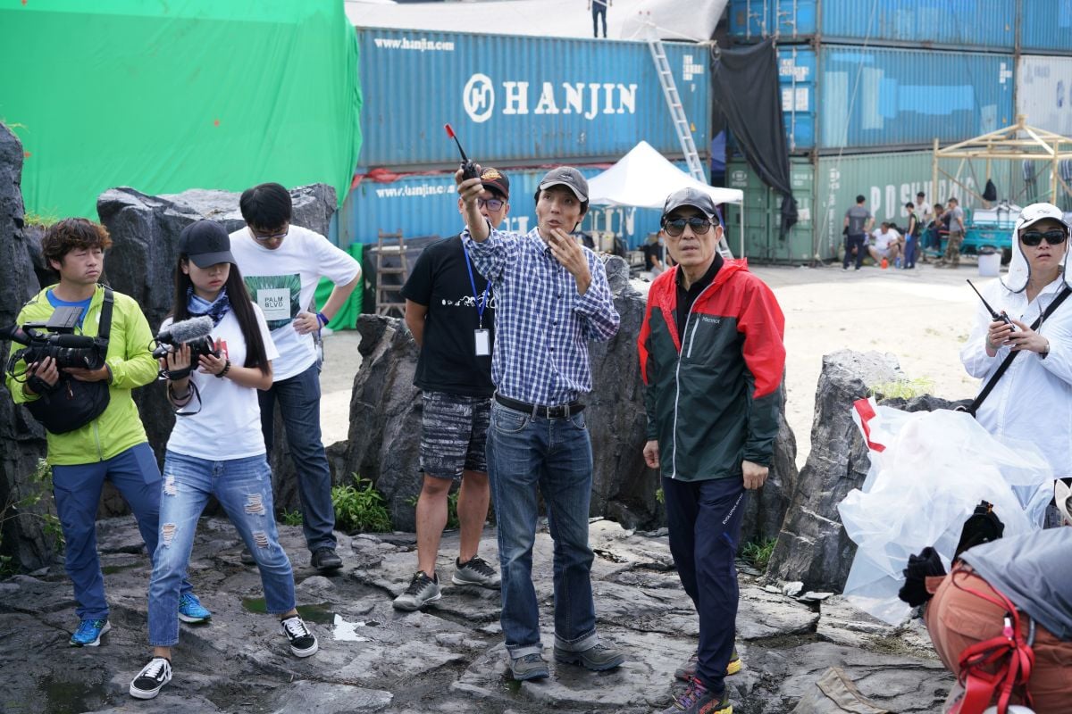Zhao Xiaoding, ASC, CNSC and director Zhang Yimou confer on set.