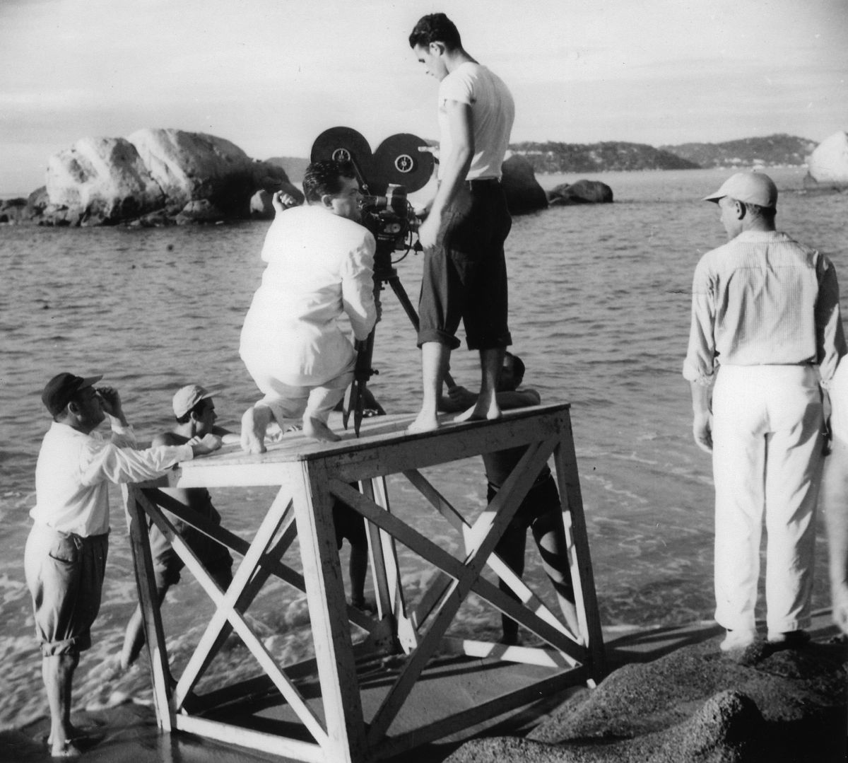 Welles examines the placement of the camera on a platform. At his side is camera assistant Richard H. Kline.