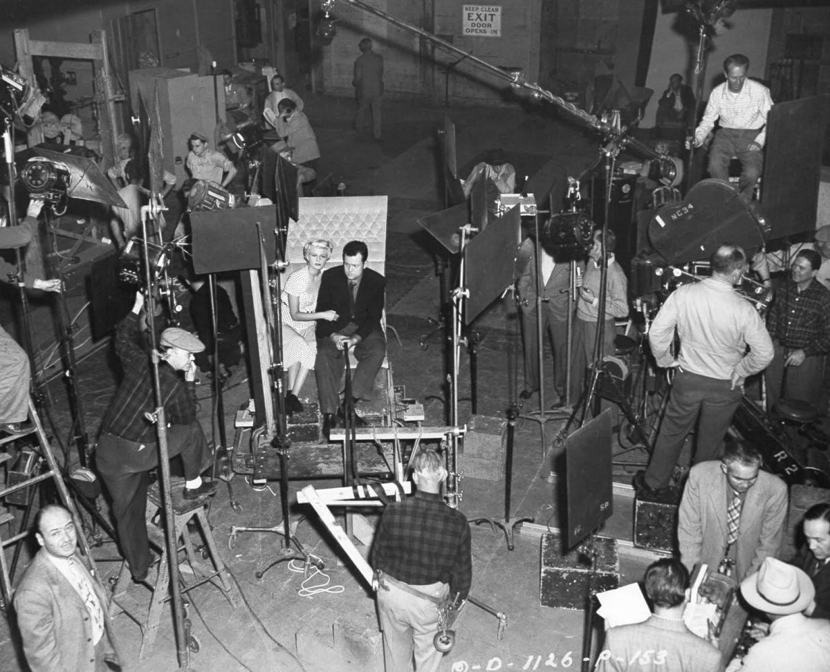 Welles and Hayworth at the center of the shot while shooting on stage at Columbia Studios.