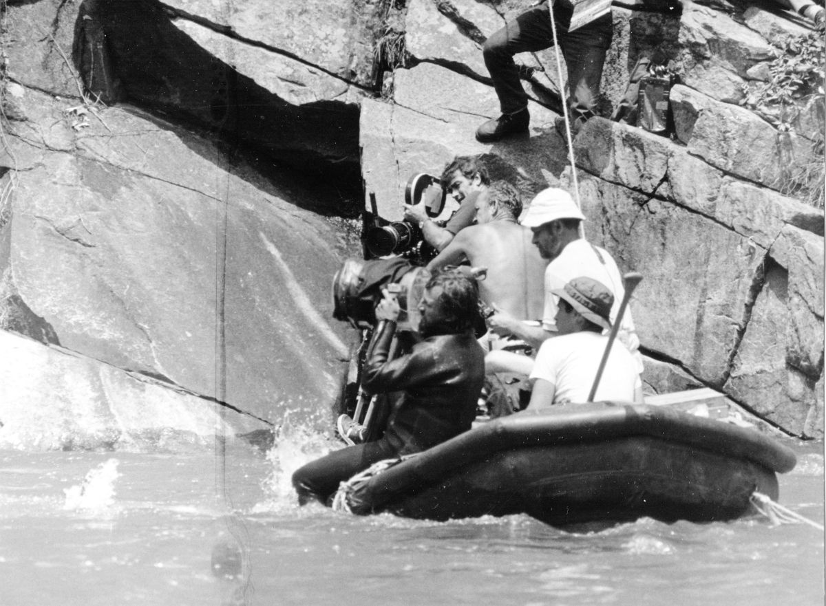 The camera crew fights the current to stay in position. Seated, clad in a wet suit and holding a camera, is Zsigmond.