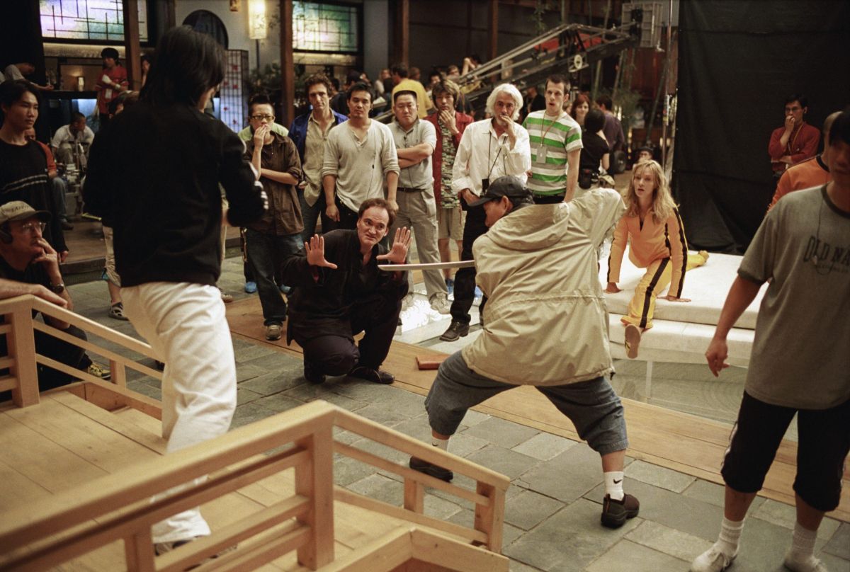 Writer-director Quentin Tarantino blocks out some swordplay with the help of the show's renowned stunt coordinator, Master Yuen-Wu Ping, as Robert Richardson, ASC (white shirt and hair) and Thurman (far right) observe with the crew.