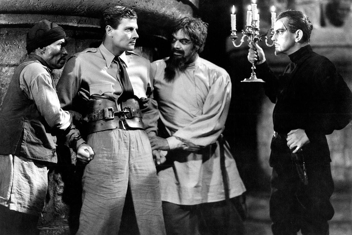 Tartar ( Steve Clemente) and Ivan restrain Rainsford as Zaroff "invites" him to a nocturnal hunt.